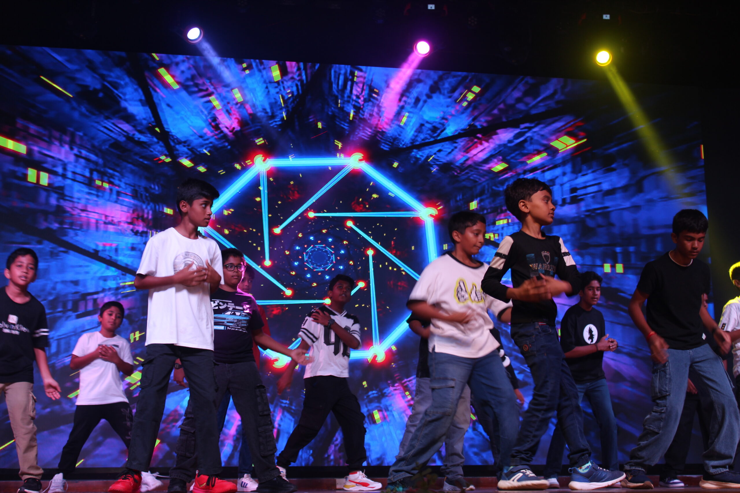Students and staff performing during Novato Fiesta 2K25 Freshers' Day celebration at De Paul International Residential School, Mysuru.