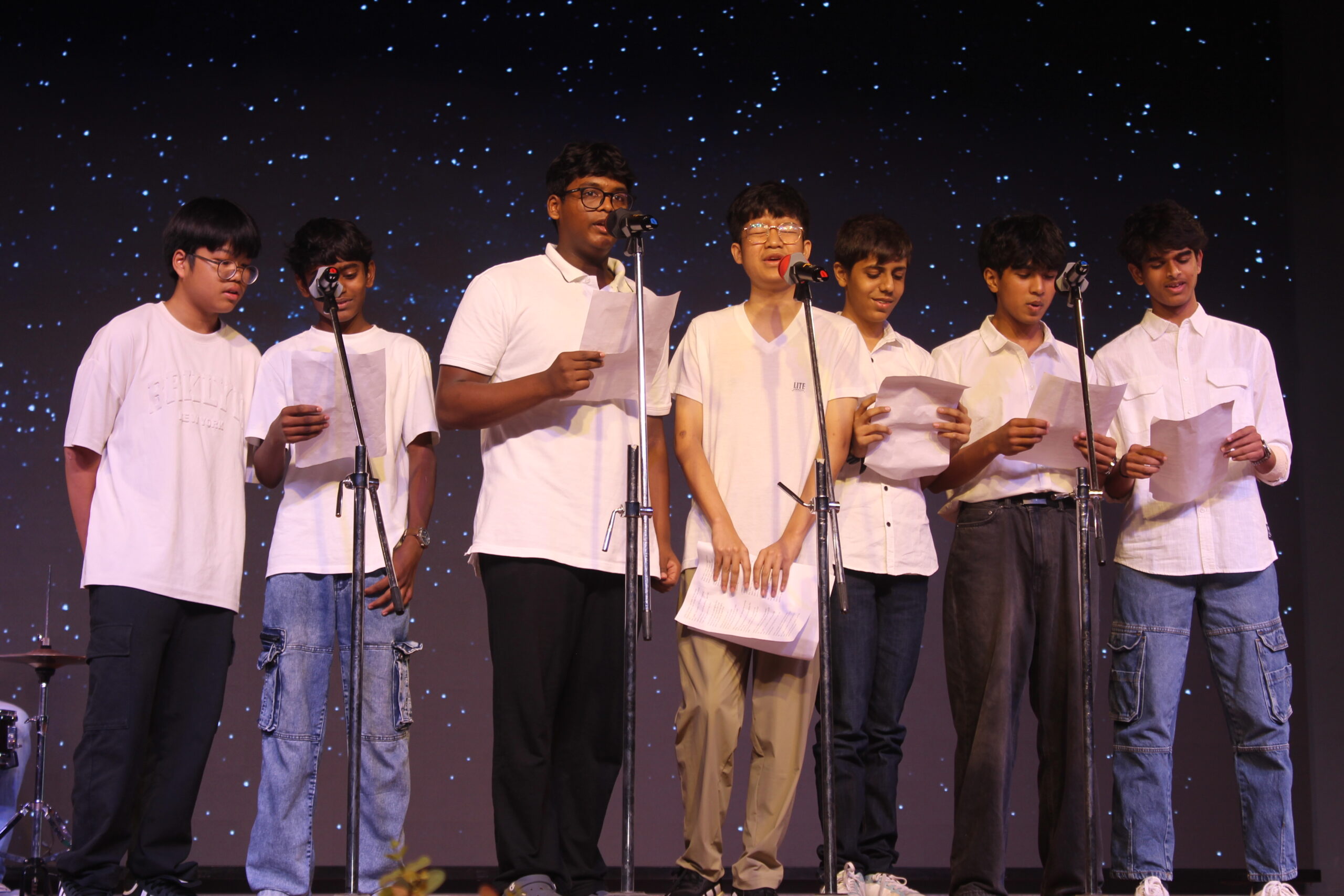 Students and staff performing during Novato Fiesta 2K25 Freshers' Day celebration at De Paul International Residential School, Mysuru.