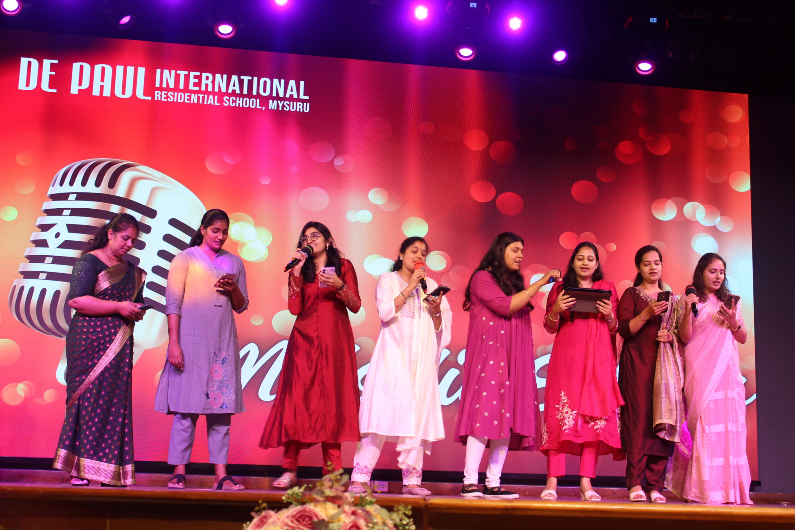 Students and staff performing during Novato Fiesta 2K25 Freshers' Day celebration at De Paul International Residential School, Mysuru.